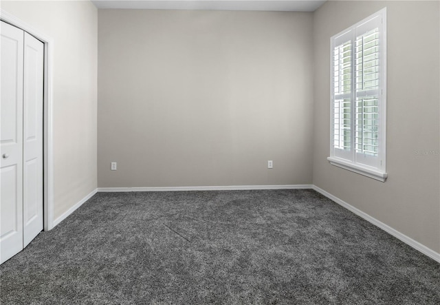 unfurnished bedroom with dark colored carpet