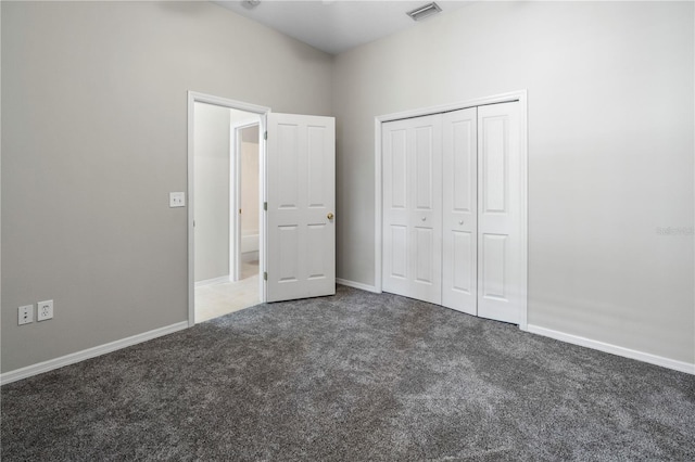 unfurnished bedroom with dark colored carpet and a closet