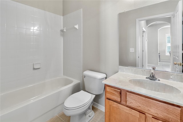 full bathroom with tile patterned flooring, tiled shower / bath combo, vanity, and toilet