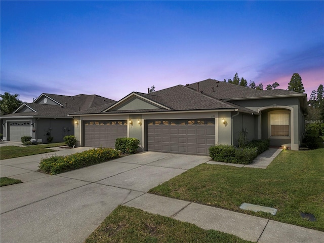 ranch-style house with a yard and a garage