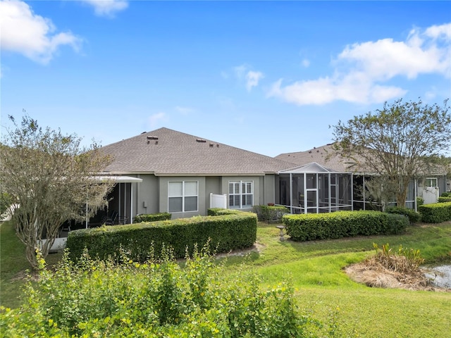 back of property with a yard and a sunroom