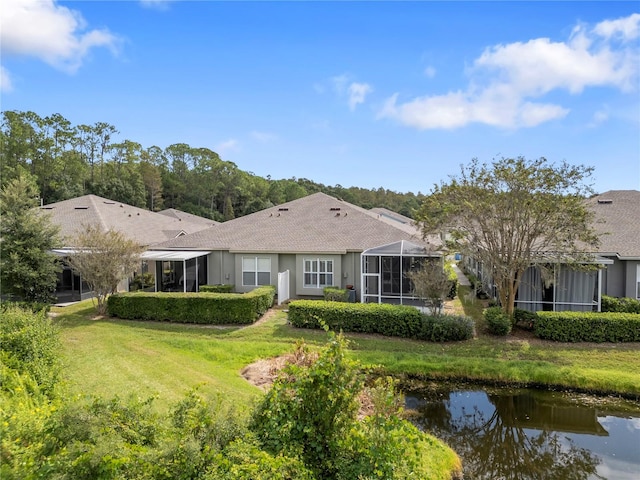 back of house with a yard and a lanai