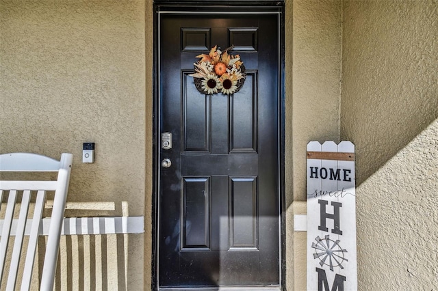 view of exterior entry with stucco siding