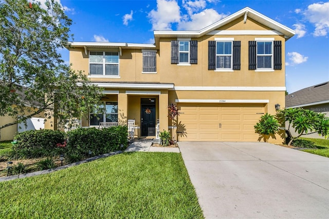 view of front facade featuring driveway, stucco siding, a front yard, and an attached garage