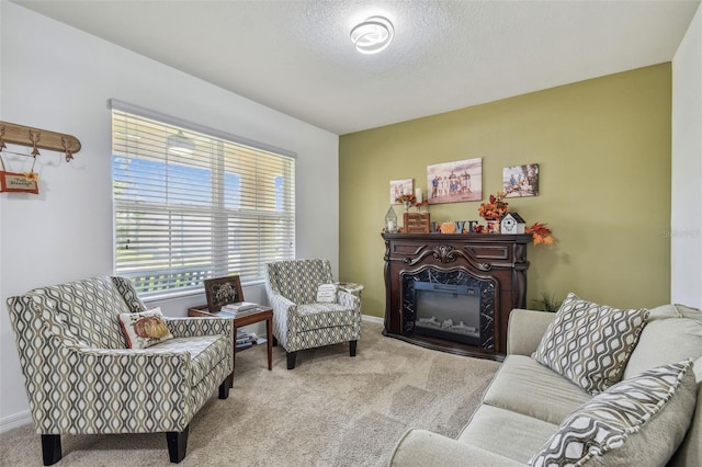 carpeted living room featuring a high end fireplace, baseboards, and a textured ceiling