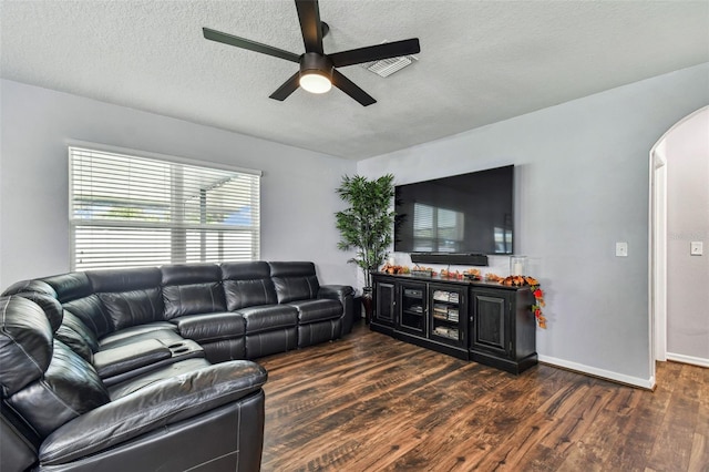 living area featuring arched walkways, a textured ceiling, wood finished floors, and a ceiling fan