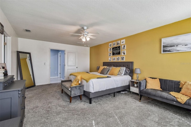 carpeted bedroom featuring a textured ceiling, baseboards, ceiling fan, and visible vents