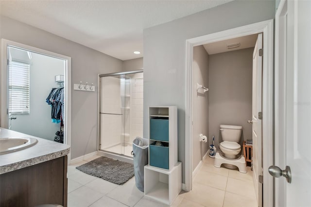 full bath with baseboards, toilet, tile patterned flooring, and a shower stall
