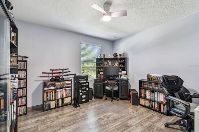 home office with a textured ceiling, ceiling fan, and light wood-type flooring