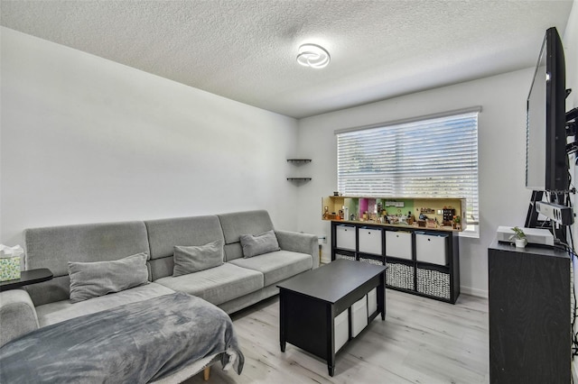 living area with a textured ceiling and light wood-type flooring