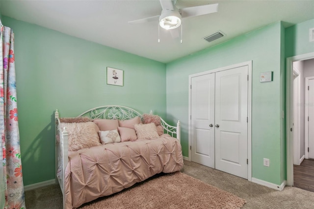 bedroom with a closet, carpet flooring, visible vents, baseboards, and ceiling fan