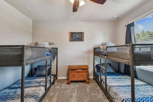 carpeted bedroom featuring a textured ceiling, baseboards, and ceiling fan