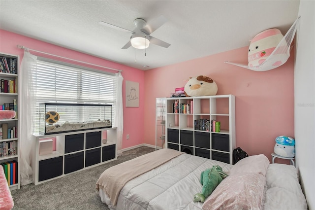 carpeted bedroom featuring baseboards, a textured ceiling, and a ceiling fan