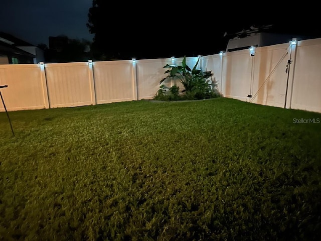 yard at twilight with a fenced backyard