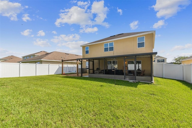 back of property with a fenced backyard, a lawn, stucco siding, and a sunroom