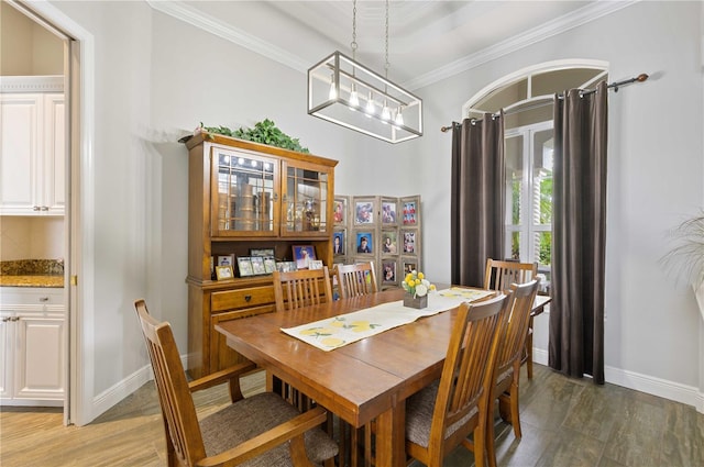 dining area with an inviting chandelier, hardwood / wood-style flooring, and crown molding