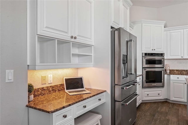 kitchen featuring decorative backsplash, white cabinets, stainless steel appliances, dark stone counters, and dark hardwood / wood-style floors