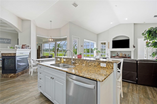 kitchen with sink, a premium fireplace, white cabinetry, dishwasher, and light hardwood / wood-style floors