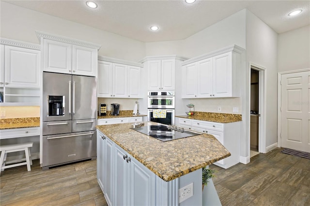 kitchen featuring light stone counters, stainless steel appliances, dark wood-type flooring, and white cabinetry