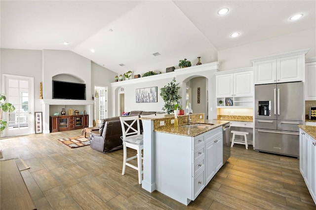 kitchen featuring light stone countertops, appliances with stainless steel finishes, dark hardwood / wood-style floors, and white cabinetry