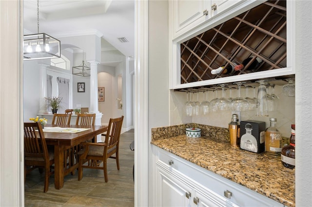 interior space with light stone counters, white cabinets, pendant lighting, and a chandelier