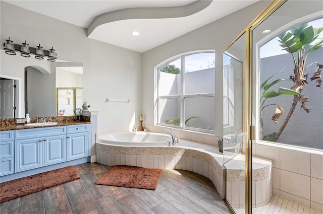 bathroom featuring independent shower and bath, vanity, and hardwood / wood-style flooring