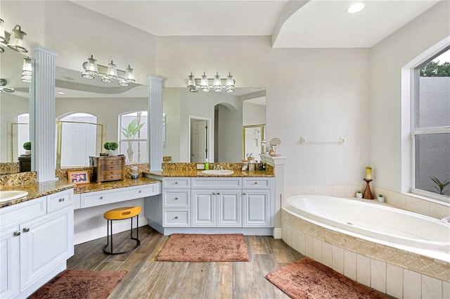 bathroom featuring ornate columns, vanity, separate shower and tub, and hardwood / wood-style flooring