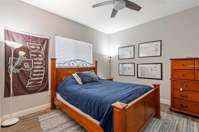 bedroom with ceiling fan, hardwood / wood-style flooring, and a textured ceiling