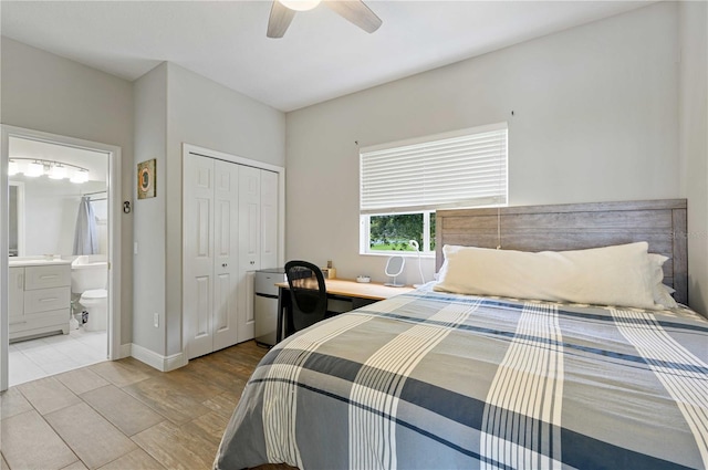 bedroom with light wood-type flooring, ensuite bath, ceiling fan, and a closet