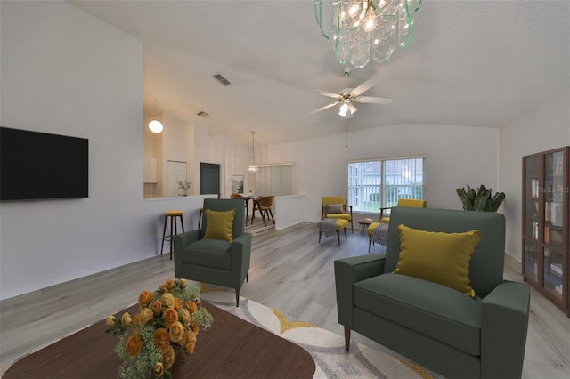 living room with a textured ceiling, ceiling fan with notable chandelier, and light hardwood / wood-style floors