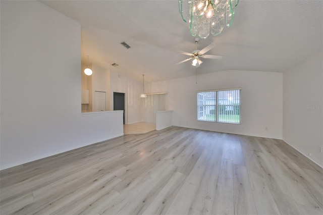 unfurnished living room with ceiling fan with notable chandelier, lofted ceiling, a textured ceiling, and light hardwood / wood-style flooring