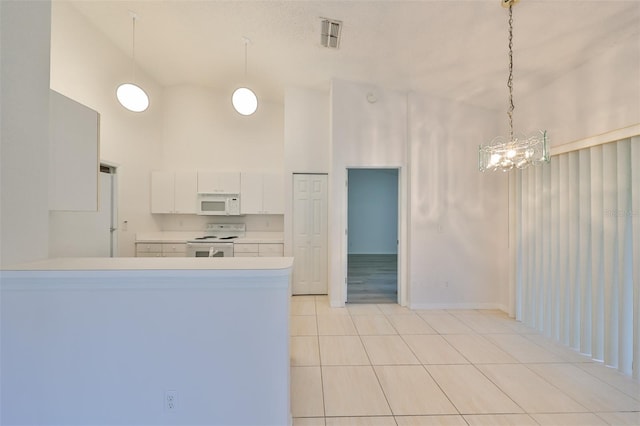 kitchen featuring kitchen peninsula, a towering ceiling, white appliances, white cabinetry, and hanging light fixtures