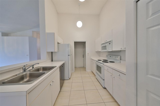 kitchen with white appliances, decorative light fixtures, white cabinetry, and sink