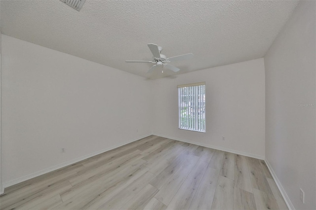 empty room featuring ceiling fan, light hardwood / wood-style floors, and a textured ceiling