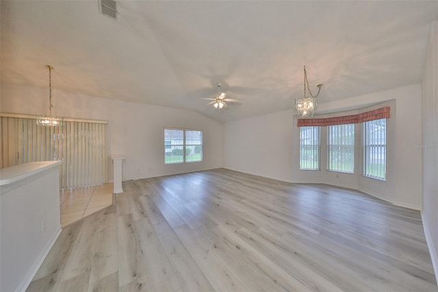 unfurnished living room featuring ceiling fan with notable chandelier, light hardwood / wood-style floors, and vaulted ceiling