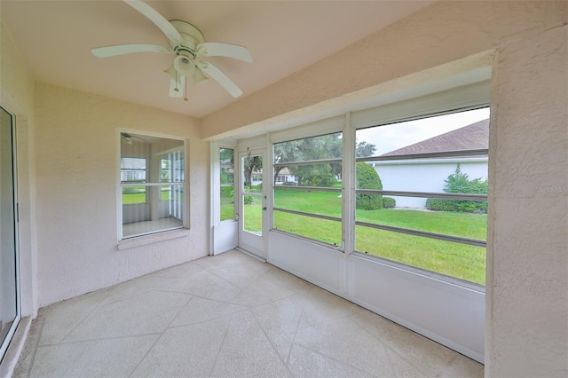 unfurnished sunroom featuring ceiling fan