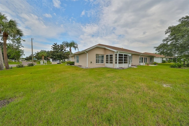 rear view of property featuring a lawn