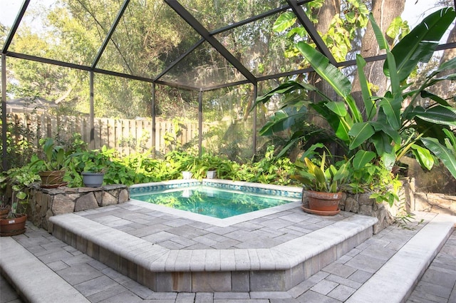 view of swimming pool featuring glass enclosure and a patio area