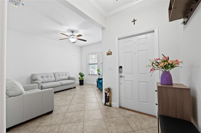 tiled entrance foyer with ceiling fan and ornamental molding