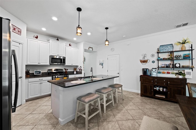 kitchen with sink, an island with sink, white cabinetry, stainless steel appliances, and ornamental molding