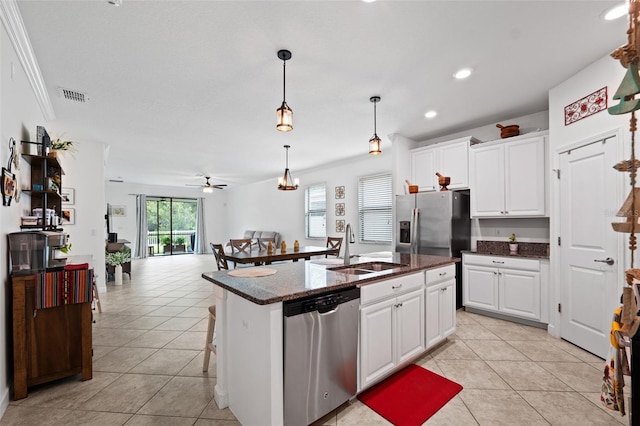 kitchen with sink, appliances with stainless steel finishes, a kitchen island with sink, and white cabinetry