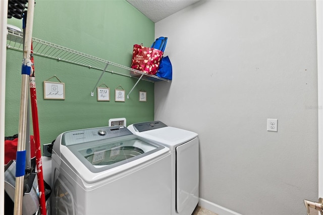 laundry area featuring a textured ceiling and washing machine and clothes dryer