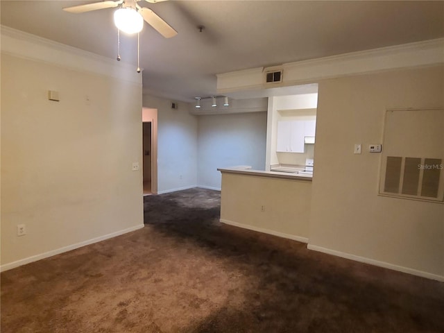 spare room featuring crown molding, track lighting, dark carpet, and ceiling fan