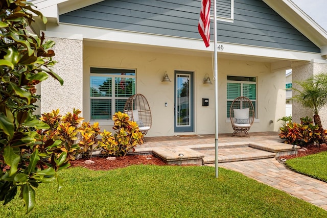 doorway to property featuring a patio and a yard