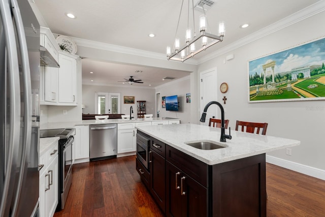 kitchen featuring dark wood-type flooring, an island with sink, kitchen peninsula, stainless steel appliances, and sink