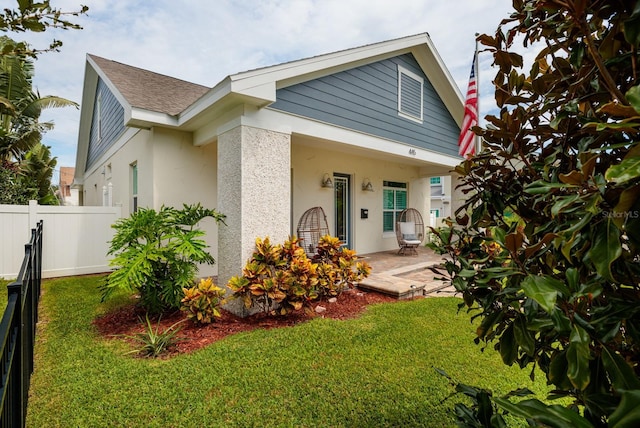 view of front facade featuring a front lawn and a patio