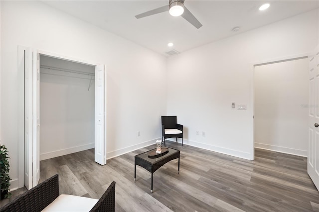 sitting room with ceiling fan and light wood-type flooring