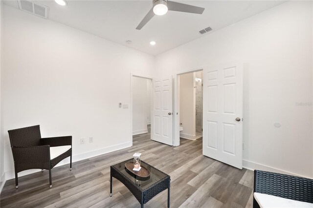 living area featuring light hardwood / wood-style floors and ceiling fan