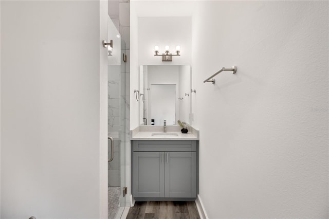 bathroom featuring wood-type flooring, vanity, and an enclosed shower