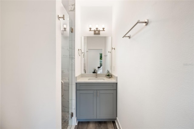 bathroom with walk in shower, vanity, and hardwood / wood-style flooring